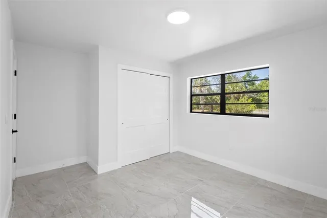 an empty room with a window and cabinet