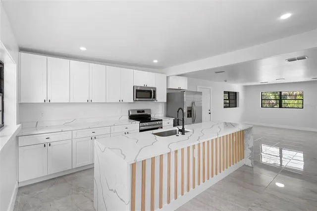 a kitchen with stainless steel appliances sink microwave and cabinets