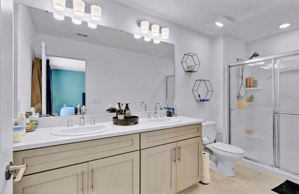3609 Anibal Street Kissimmee, FL 34746 - Photo 14 of 17 a bathroom with a toilet a sink a shower a mirror and vanity