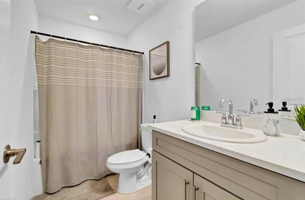 3609 Anibal Street Kissimmee, FL 34746 - Photo 15 of 17 a bathroom with a sink a toilet and shower curtain
