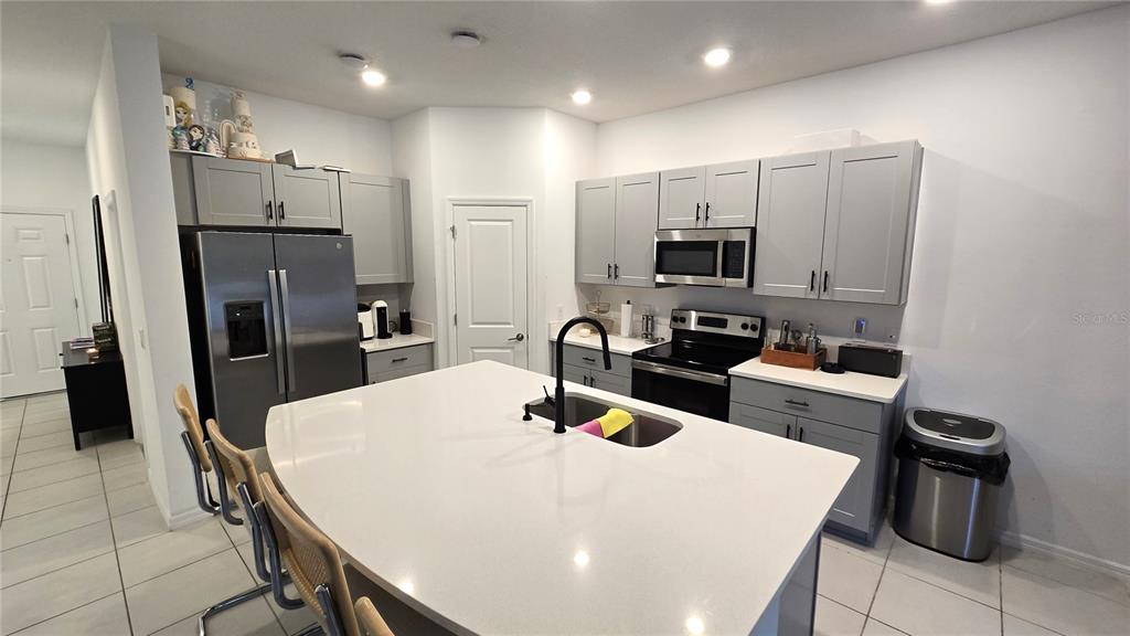 3609 Anibal Street Kissimmee, FL 34746 - Photo 7 of 17 a kitchen with a refrigerator a stove a sink a dining table and chairs