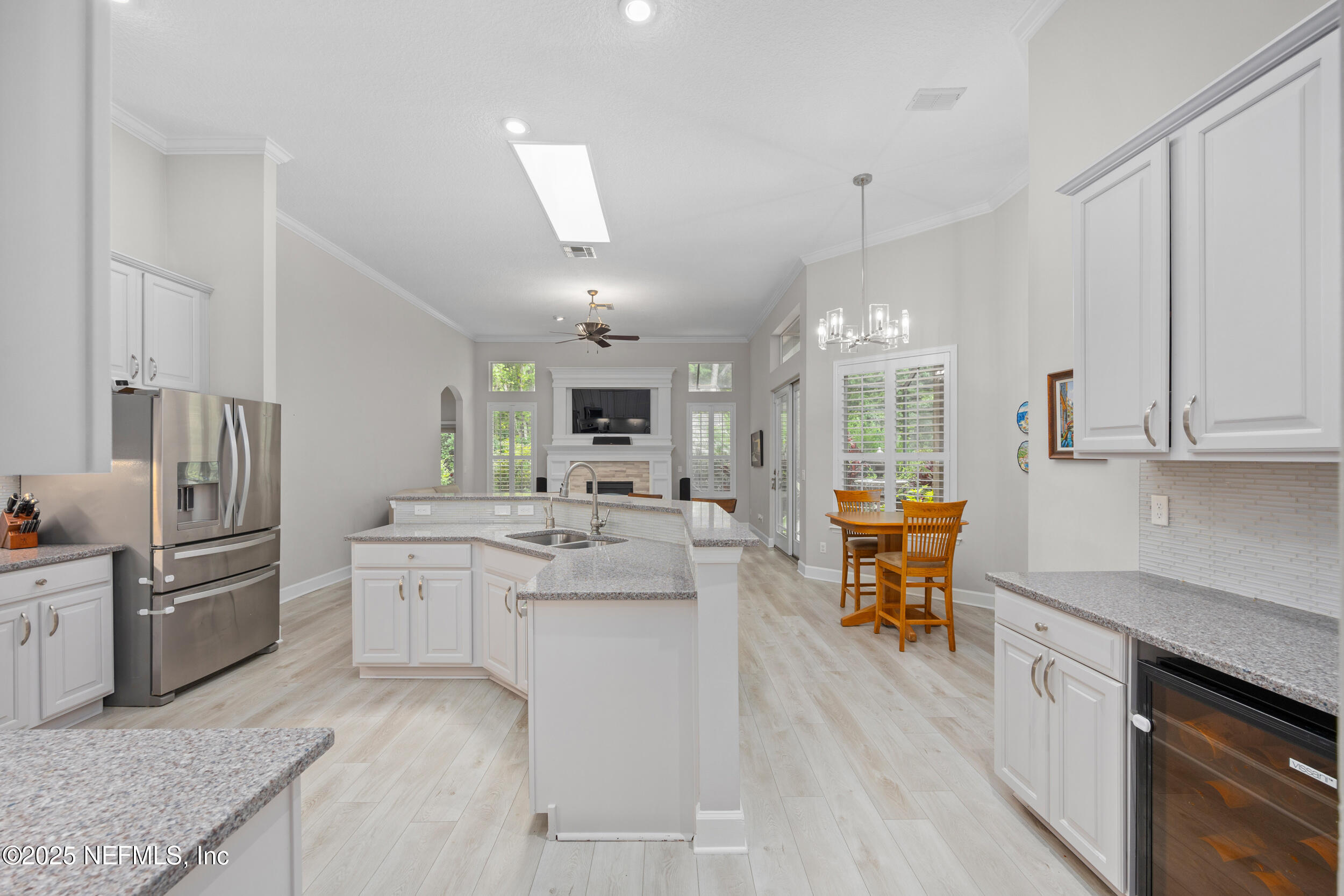 1854 West Cobblestone Lane St. Augustine, FL 32092 - Photo 19 of 72 a kitchen with stainless steel appliances kitchen island granite countertop a sink dishwasher a stove a dining table and chairs with wooden floor
