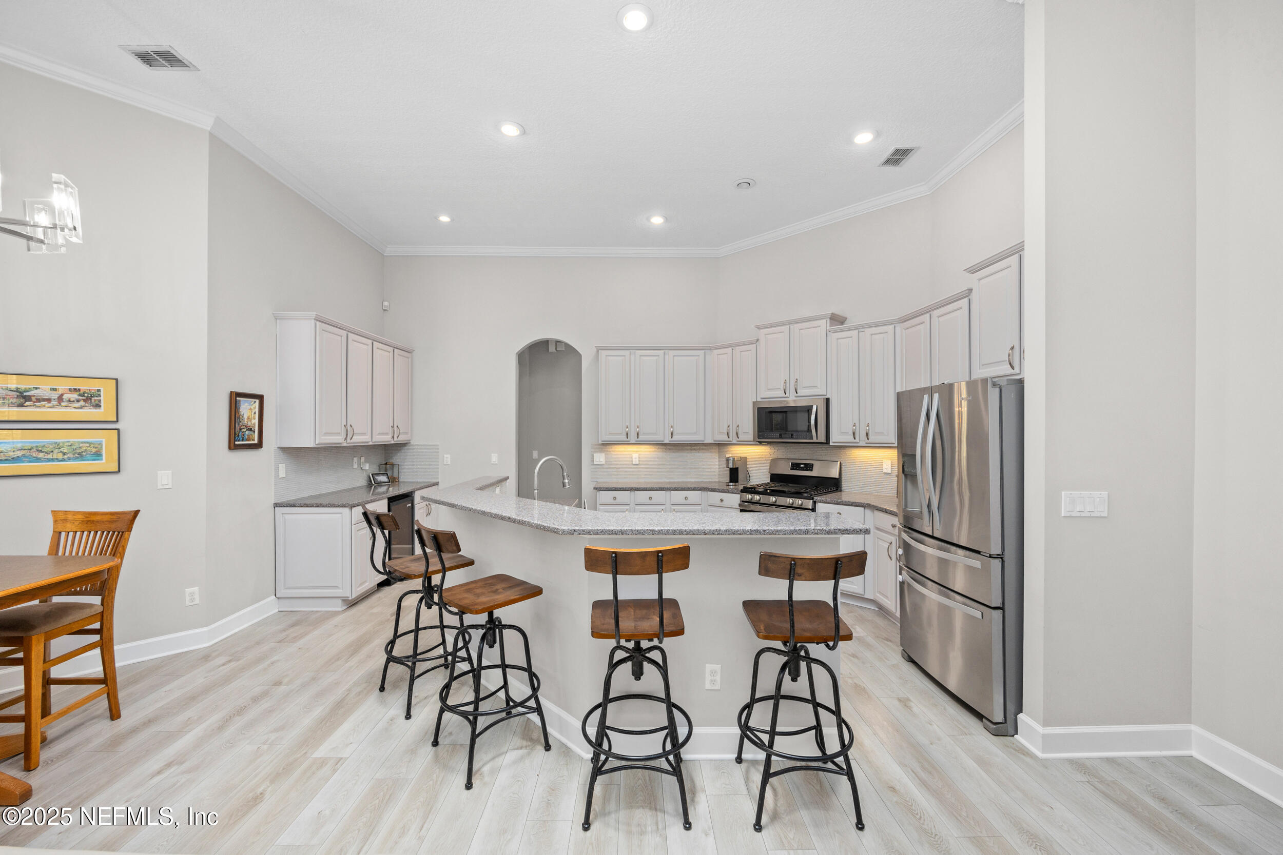 1854 West Cobblestone Lane St. Augustine, FL 32092 - Photo 23 of 72 a kitchen with stainless steel appliances a dining table and chairs in it