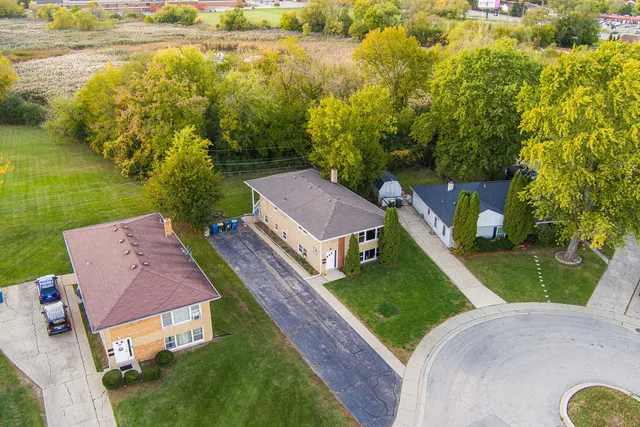 an aerial view of residential houses with outdoor space and trees