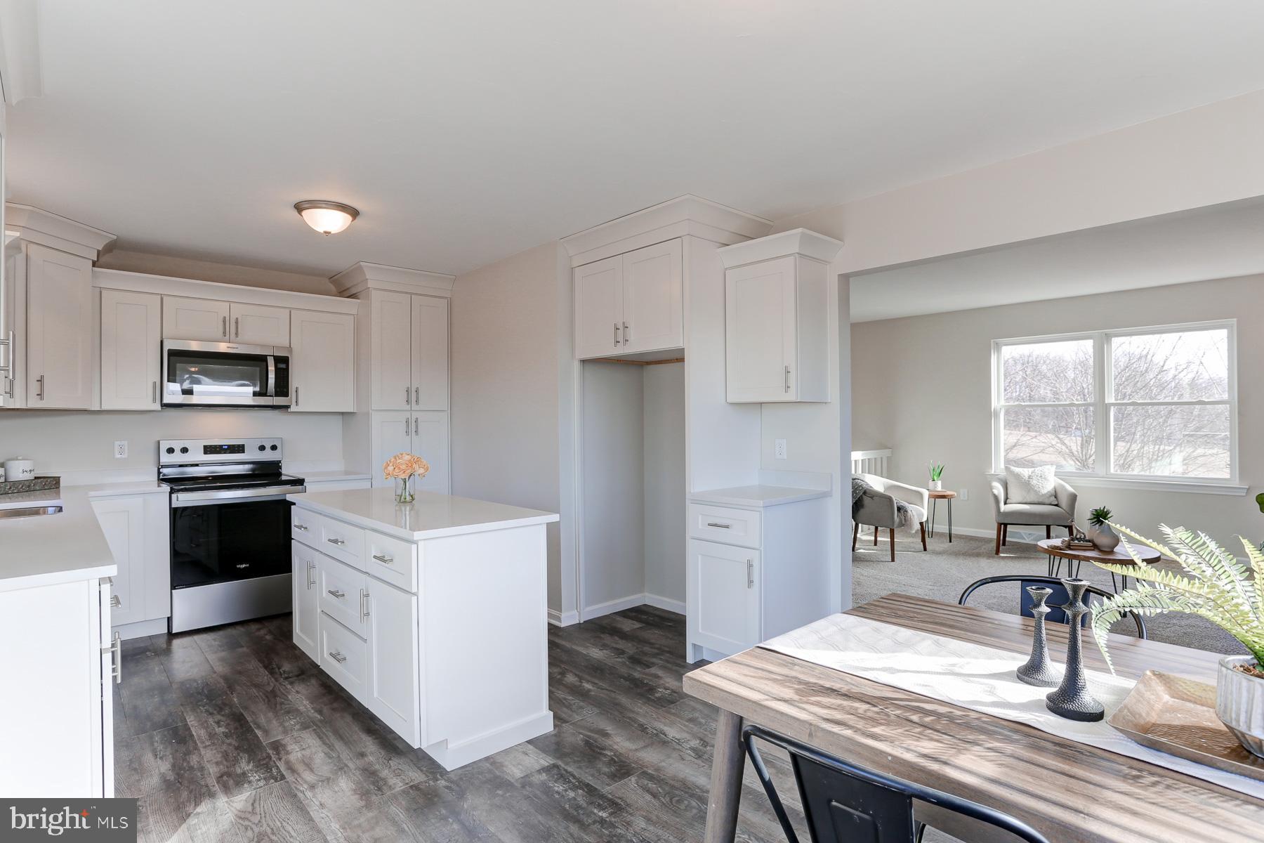 434 Fuhrman Mill Road Hanover, PA 17331 - Photo 5 of 32 a kitchen with stainless steel appliances a stove a sink a refrigerator white cabinets and wooden floor