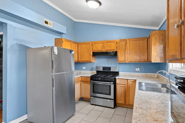 a kitchen with stainless steel appliances granite countertop a refrigerator sink and stove