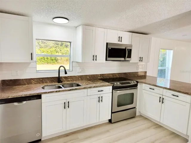 a view of a room with wooden floor and ceiling fan