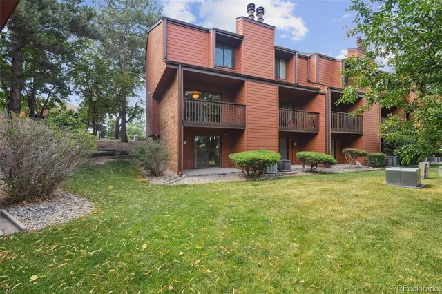 a view of a brick house with a yard and plants
