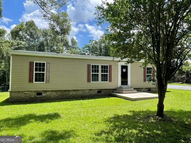 a view of a house with backyard and sitting area