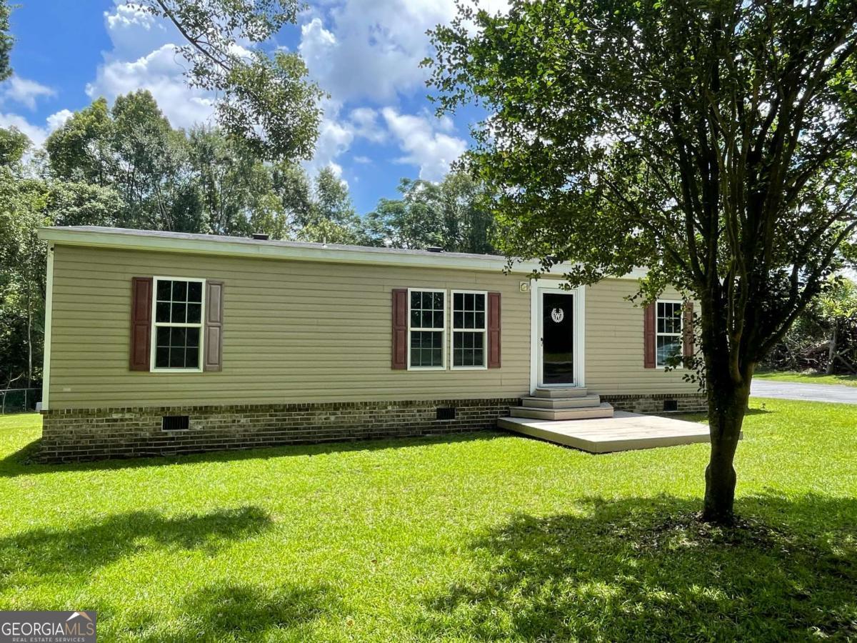 a view of a house with backyard and sitting area