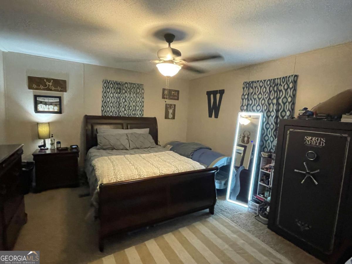 601 Auburn Road Glennville, GA 30427 - Photo 12 of 17 a bedroom with a bed and wooden floor