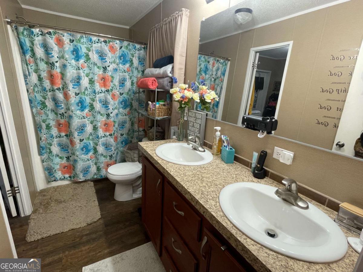 601 Auburn Road Glennville, GA 30427 - Photo 13 of 17 a bathroom with a granite countertop sink and a mirror