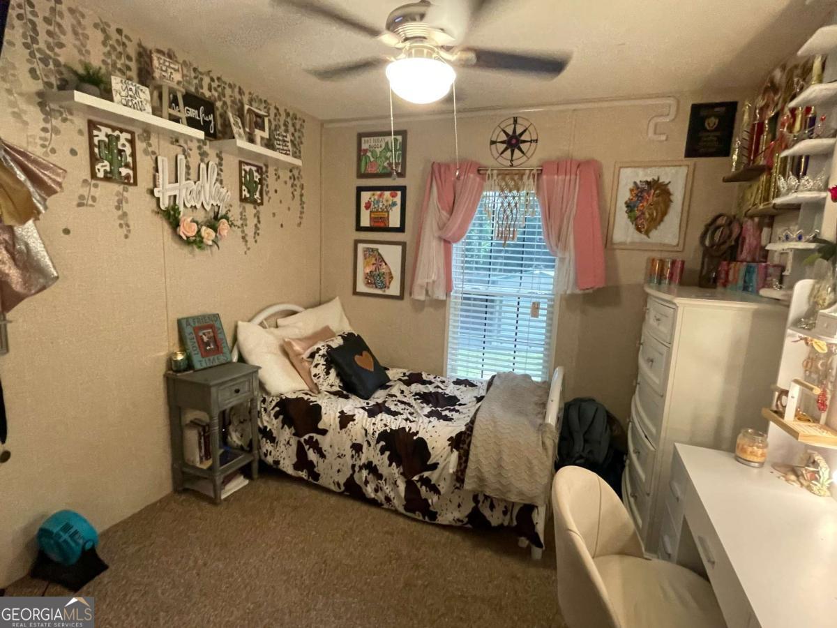 601 Auburn Road Glennville, GA 30427 - Photo 14 of 17 a bedroom with furniture and a chandelier