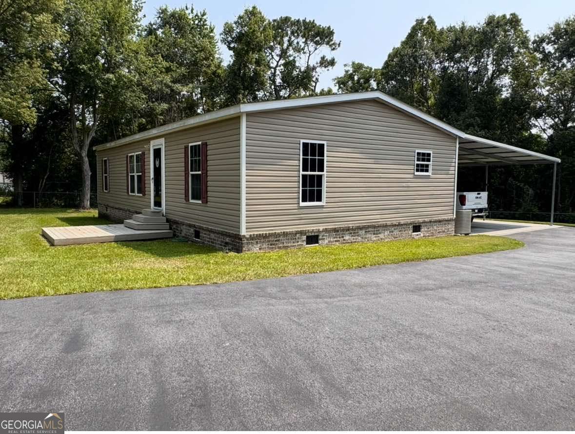 601 Auburn Road Glennville, GA 30427 - Photo 3 of 17 a view of a house with a yard and potted plants