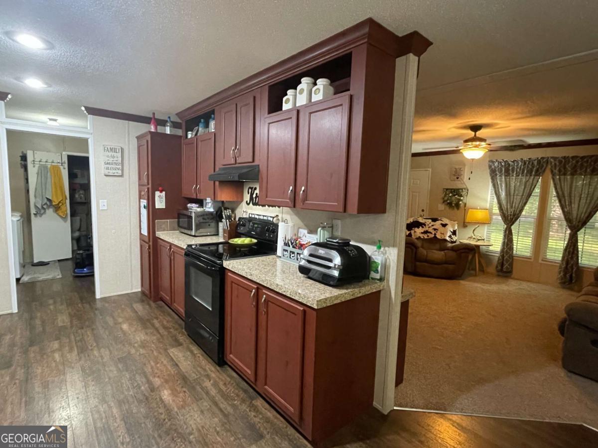 601 Auburn Road Glennville, GA 30427 - Photo 10 of 17 a kitchen with a stove a sink and a refrigerator