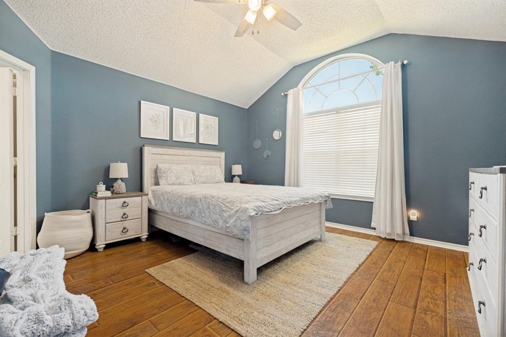 11709 Harbor Road Frisco, TX 75035 - Photo 10 of 12 a bedroom with a bed and a chandelier