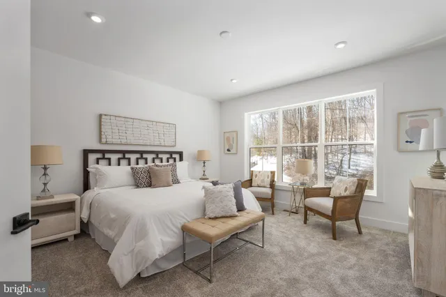 a bedroom with a large bed and windows