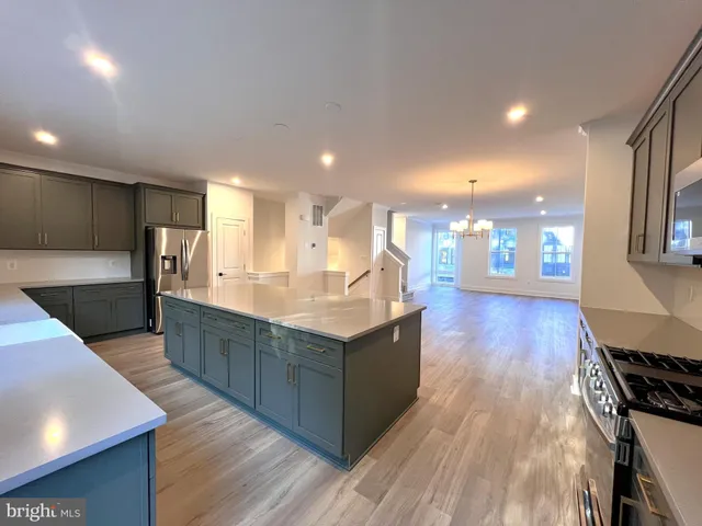 a kitchen with stainless steel appliances granite countertop a stove and a wooden floors
