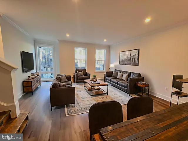 a living room with furniture flat screen tv and wooden floor