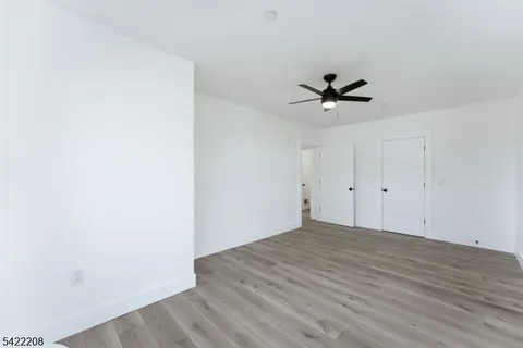 a view of a room with wooden floor and a ceiling fan