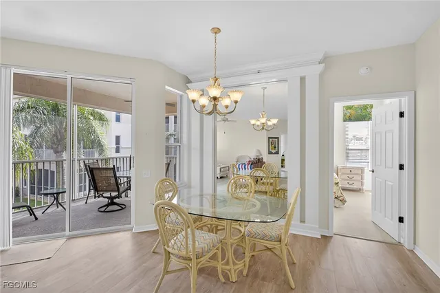 a dining room with chandelier and wooden floor