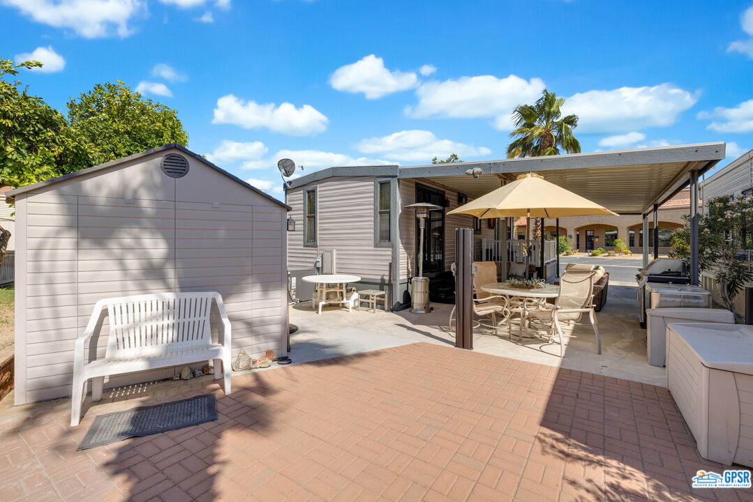 69801 Ramon Road, Unit 28 Cathedral City, CA 92234 - Photo 7 of 20 a patio with a table and chairs under an umbrella