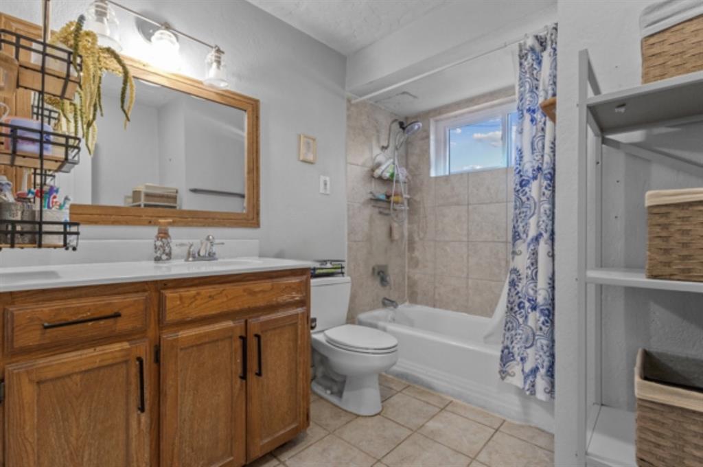 1401 Apache Street Arlington, TX 76012 - Photo 14 of 17 a bathroom with a granite countertop sink a toilet and shower