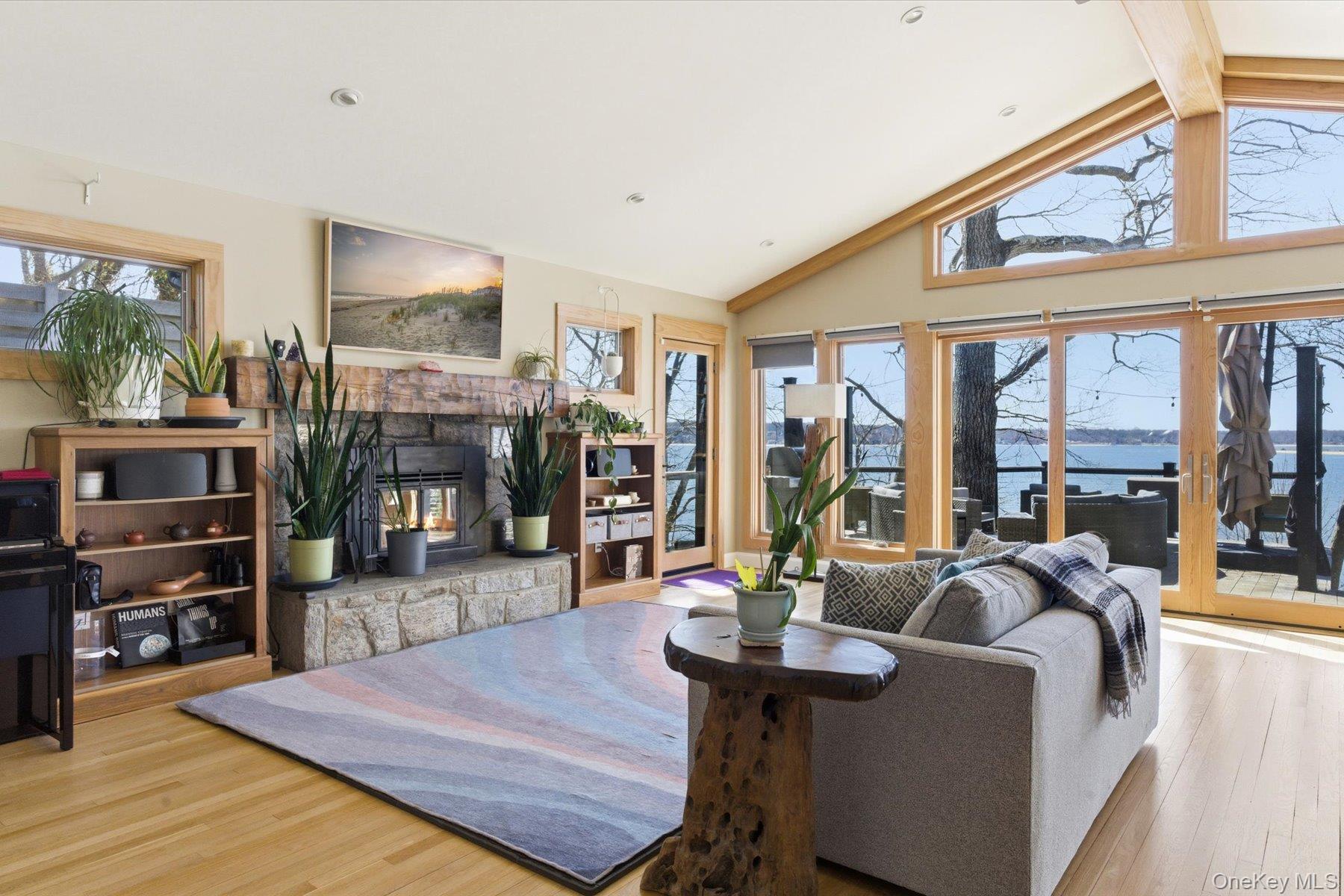 154 Eatons Neck Road Northport, NY 11768 - Photo 12 of 39 a living room with furniture a flat screen tv and a floor to ceiling window