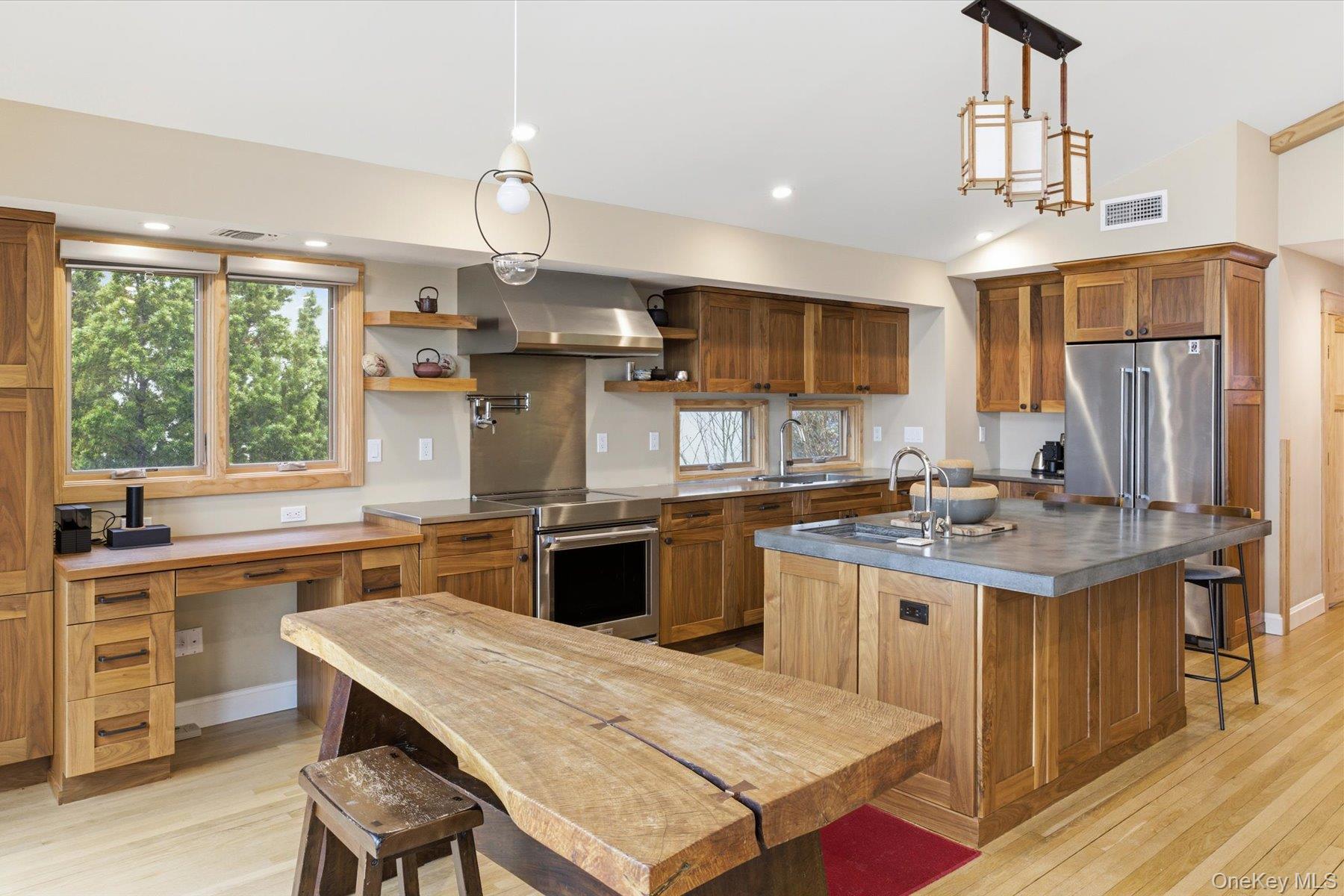 154 Eatons Neck Road Northport, NY 11768 - Photo 24 of 39 a kitchen with stainless steel appliances granite countertop a stove refrigerator a sink dishwasher a dining table and chairs with wooden floor