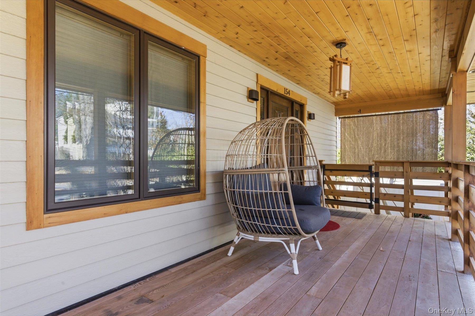 154 Eatons Neck Road Northport, NY 11768 - Photo 4 of 39 a porch with seating space and wooden floor