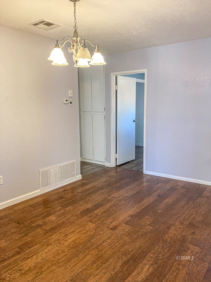 216 West Boston Avenue Ridgecrest, CA 93555 - Photo 8 of 36 an empty room with wooden floor and windows
