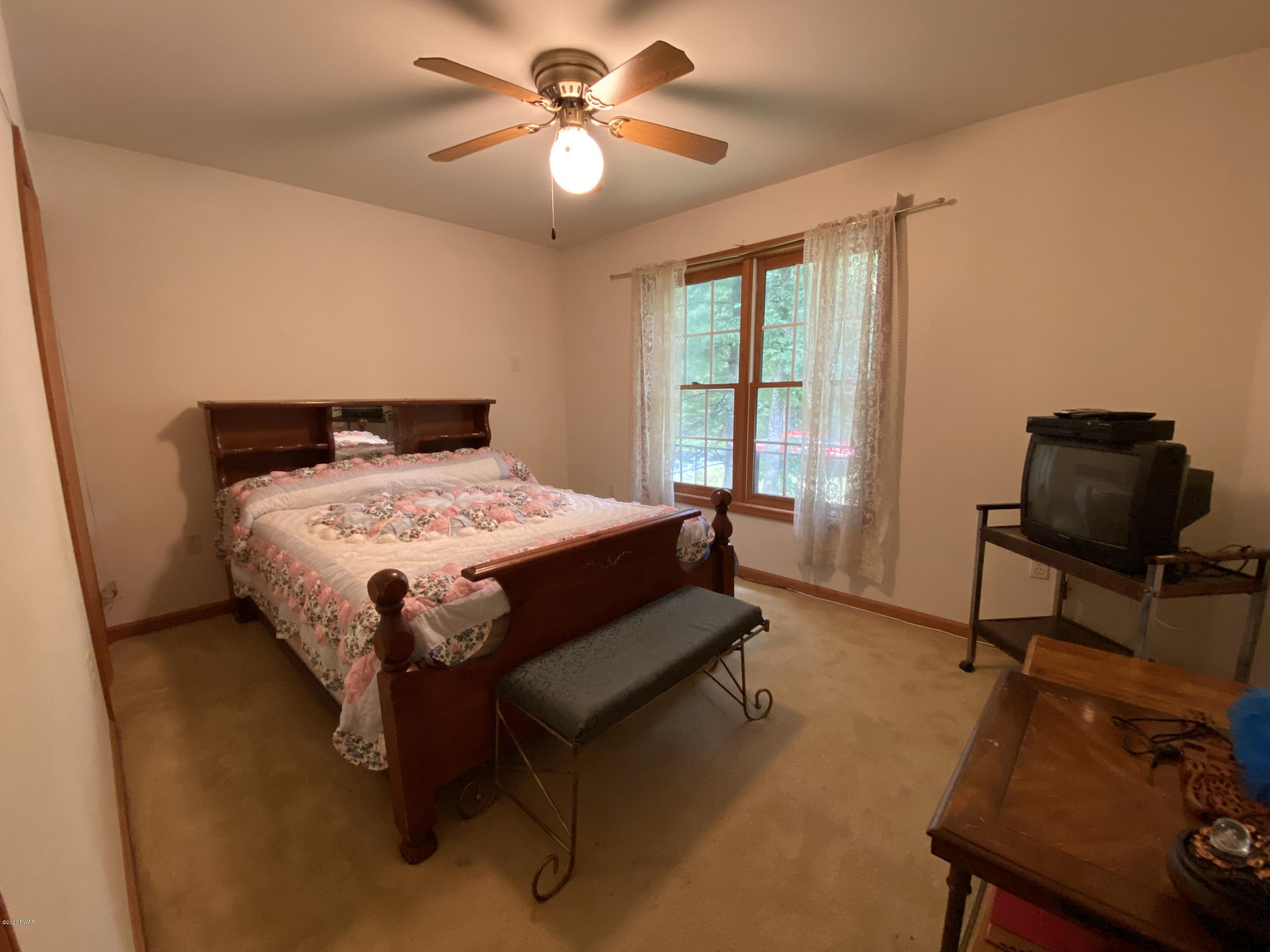 111 Beecher Road Dingmans Ferry, PA 18328 - Photo 16 of 25 a bed sitting in a bedroom next to a window