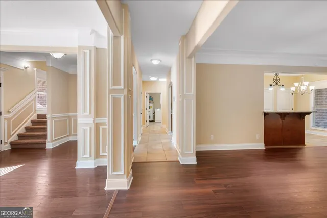 a view of a hallway with wooden floor and a room