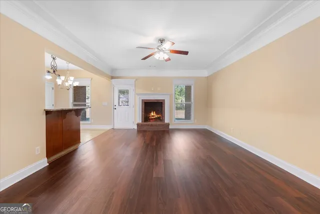 a view of a livingroom with wooden floor a fireplace and window