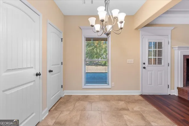 a view of a livingroom with a chandelier fan and windows