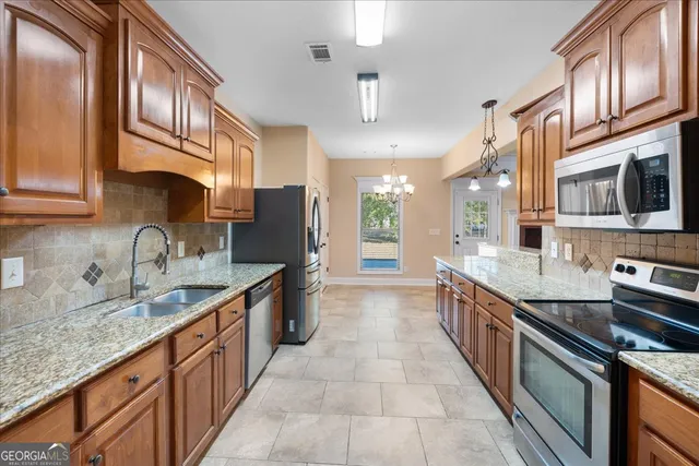 a large kitchen with stainless steel appliances granite countertop a sink and cabinets