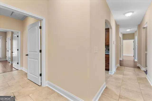 en view of a hallway with wooden floor and a bathroom