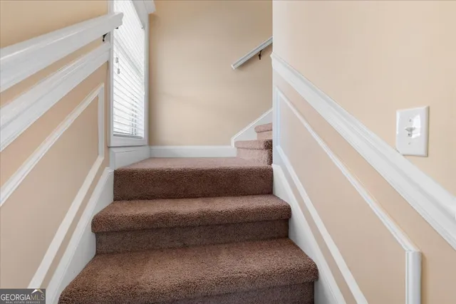 a living room with furniture and stairs