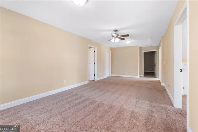 a view of an empty room with a ceiling fan