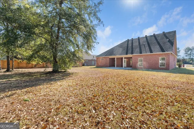 a view of house with backyard and trees