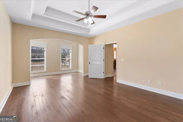 a view of an empty room with a window and wooden floor