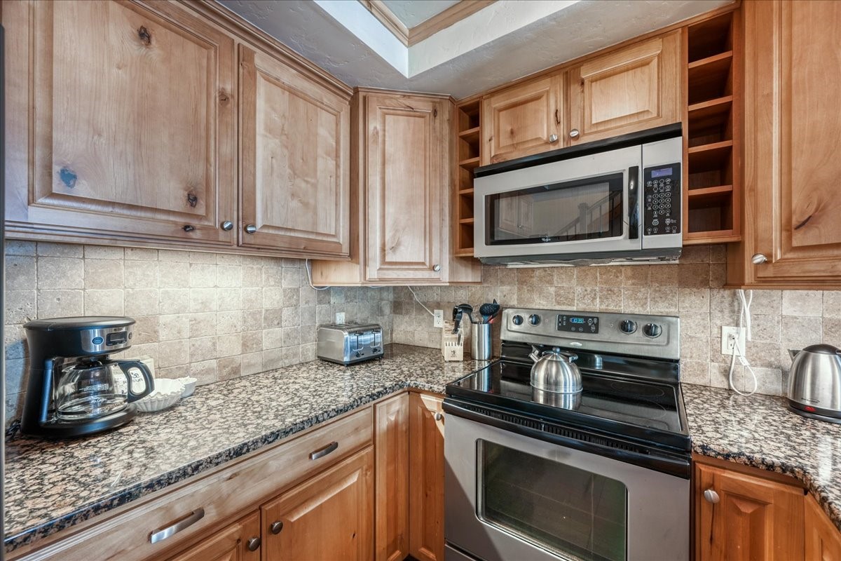 200 North Ridge Street, Unit R A Breckenridge, CO 80424 - Photo 8 of 38 a kitchen with stainless steel appliances granite countertop a stove microwave and cabinets