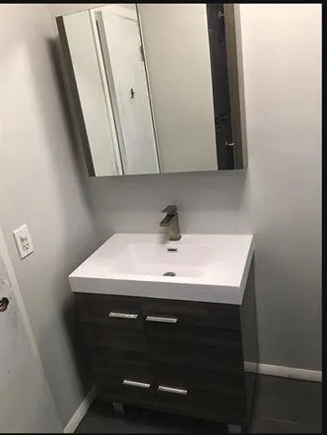 a bathroom with a toilet a sink and mirror