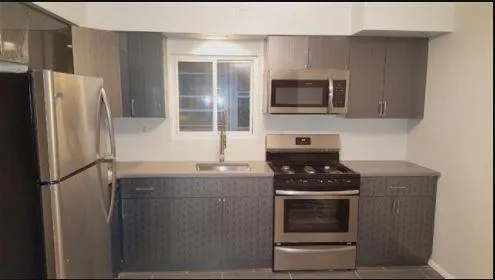 a kitchen with granite countertop a refrigerator stove and microwave
