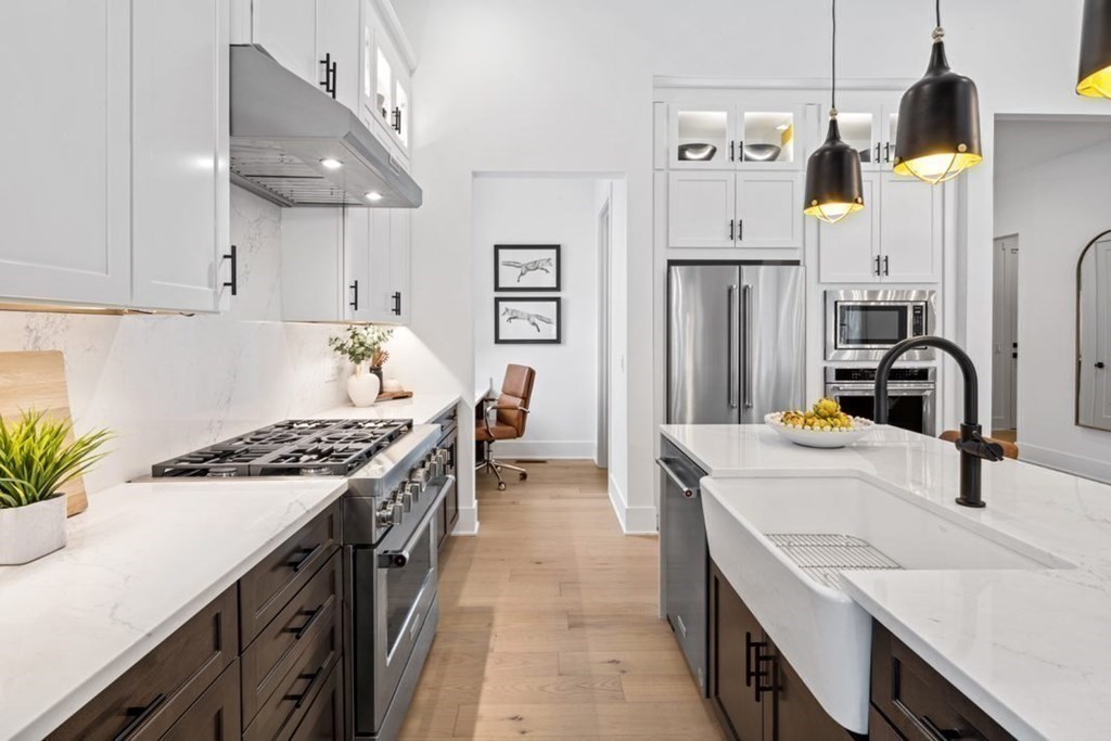 27 Barnes Boulevard, Unit 13 Hudson, MA 01749 - Photo 3 of 12 a kitchen with stainless steel appliances a sink stove and refrigerator