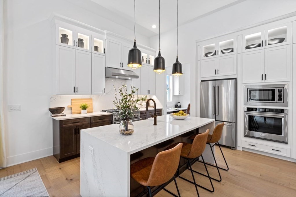 27 Barnes Boulevard, Unit 13 Hudson, MA 01749 - Photo 4 of 12 a kitchen with stainless steel appliances kitchen island granite countertop a dining table and chairs
