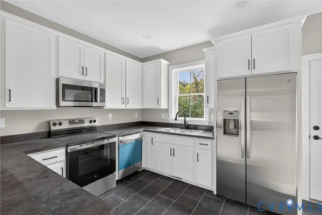 a kitchen with white cabinets and stainless steel appliances