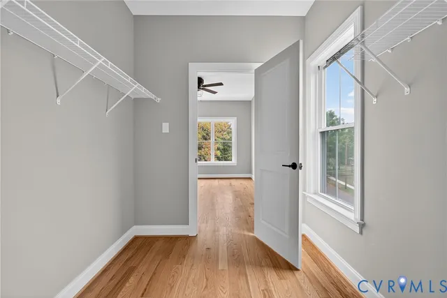 a view of hallway with a large window and wooden floor