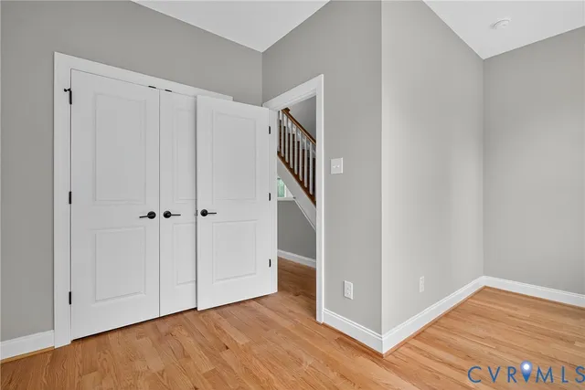 a view of an empty room with wooden floor and entryway