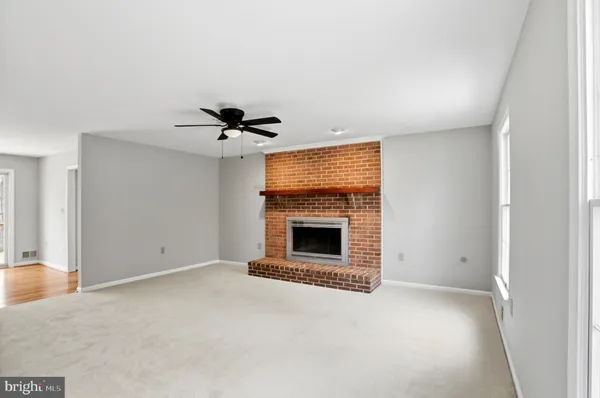 a view of an empty room with a fireplace and a window